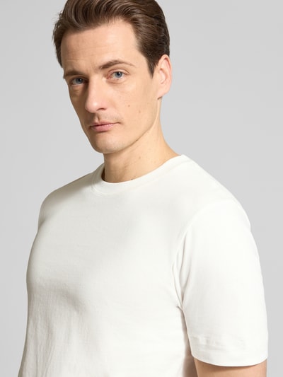 Männermodel trägt T-Shirt mit Rundhalsausschnitt von Drykorn in Weiß, reine Baumwolle, Regular Fit, Nahaufnahme Oberkörper.