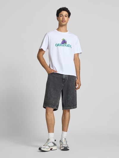 Männermodel trägt Regular Fit T-Shirt mit Statement-Print Modell 'Eres' von Jack & Jones aus Reiner Baumwolle, Ganzkörperansicht von vorne.