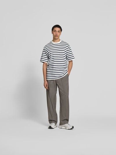 Männermodel trägt T-Shirt mit Rundhalsausschnitt von Filippa K, Reine Baumwolle, Relaxed-Fit, Kurzärmelig, Rückenlänge 76 cm, Ganzkörperansicht von vorne.