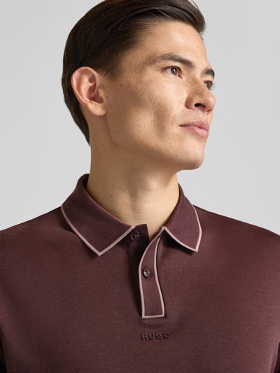 Männermodel trägt Regular Fit Poloshirt aus reiner Baumwolle Modell 'DALUMO' von HUGO, unifarben, Label-Schriftzug, Nahaufnahme Oberkörper