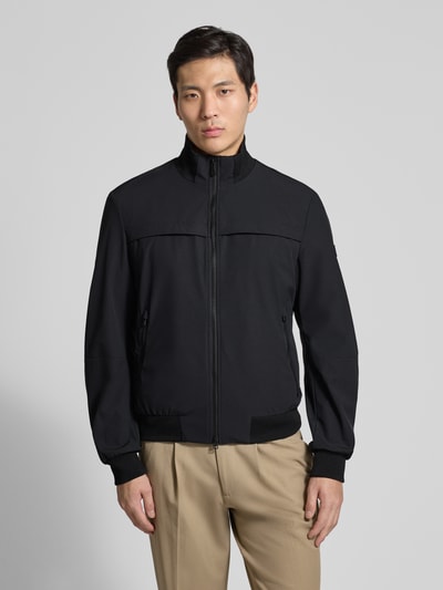 Männermodel trägt Jacke mit Stehkragen Modell 'POTOSI' von Peuterey in Schwarz, Material-Mix mit Stretch, Ganzkörperansicht von vorne.