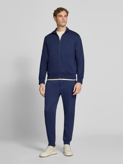 Männermodel trägt Relaxed Fit Sweatjacke aus Baumwoll-Mix von Polo Ralph Lauren in Dunkelblau, glatte Struktur, Ganzkörperansicht von vorne. Herren Sweatjacke von Polo Ralph Lauren.