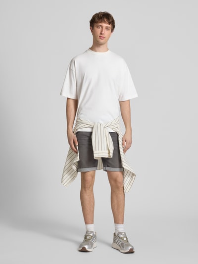 Männermodel trägt Regular Fit Bermudas aus Baumwoll-Mix mit Viskose-Anteil Modell 'PLY' von Only & Sons in dunklem Denim-Look, Ganzkörperansicht von vorne.