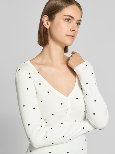 Frauenmodel trägt Regular Fit Langarmshirt aus Baumwoll-Mix Modell 'FENJA' von ONLY, weiß mit schwarzen Punkten, Nahaufnahme Oberkörper, Damen Langarmshirt von ONLY.