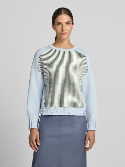 Frauenmodel trägt Sweatshirt aus Viskose-Mix von Marc Cain in Hellblau mit Streifenmuster, geripptem Rundhalsausschnitt und Tunnelzug, lockere Passform, Strickbesatz, Ganzkörperansicht von vorne.