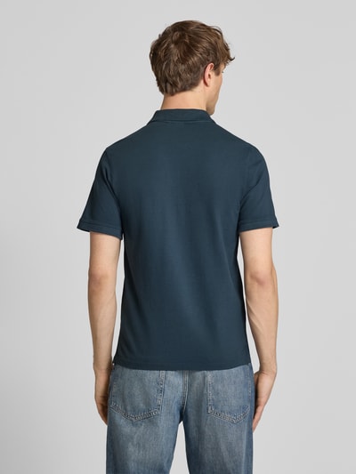 Männermodel trägt Regular Fit Poloshirt aus reiner Baumwolle Modell 'OSCAR' von Pepe Jeans, efekt: jednolity kolor, krój regular fit, wyhaftowane logo, kołnierzyk polo, dekolt w serek, krótkie zapięcie na guziki, krótki rękaw, zakończenia rękawów prążkowane, wykończenie z rozcięciami po bokach, wykończenie materiału: pika, materiał: bawełna, Ganzkörperansicht Rückansicht.