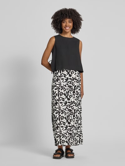 Frauenmodel trägt Maxi-Rock aus reiner Viskose Modell 'BARRI' von Pieces, Optik:Allover-Muster, Passform: Schmal, Maxi-Länge, Bundabschluss: Elastisch, Material: reine Viskose, Schwarz-Weiß-Kontrast, Ganzkörperansicht von vorne.