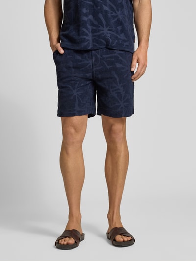 Männermodel trägt Regular Fit Sweatshorts aus Baumwoll-Mix Modell 'SE_FLOWER' von BOSS Orange, unifarben, Frottee, Ganzkörperansicht von vorne.