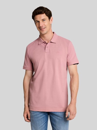 Männermodel trägt Regular Fit Poloshirt aus Baumwoll-Mix von Tom Tailor in Rosa, glatte Textur, Jeans, Ganzkörperansicht von vorne, Herren Poloshirt von Tom Tailor.