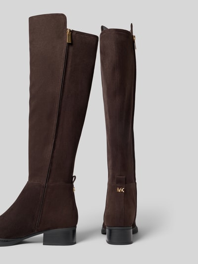 Produktfoto, Stiefel mit Label-Detail von MICHAEL Michael Kors in dunklem Braun mit metallic Label, Blockabsatz und glatter Sohle, Schaft hoch, seitlicher Reißverschluss, runde Form, Absatzhöhe ca. 4 cm, Schafthöhe 47 cm, Schaftweite 19 cm