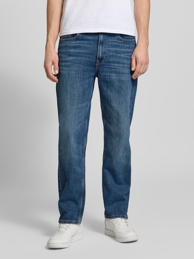 Männermodel trägt Tapered Fit Jeans aus Baumwoll-Mix Modell 'SONNY' von Tommy Jeans, niebieski denim z nitami, 5 kieszeni, krój tapered fit, zapięcie na guzik i zamek, naszywka z logo, mieszanka bawełny, Ganzkörperansicht von vorne