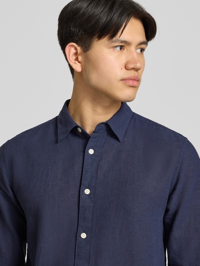 Männermodel trägt Slim Fit Freizeithemd aus Baumwoll-Leinen-Mix Modell 'CAIDENLS SOLID' von Only & Sons in Dunkelblau, Nahaufnahme Oberkörper.