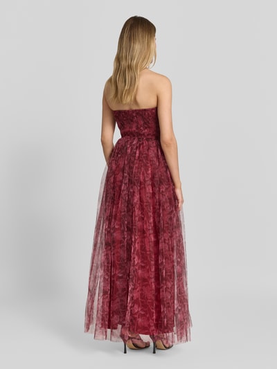 Vrouwenmodel draagt Maxikleid im Off-Shoulder-Look van Lace & Beads met tule, A-lijn, tailleband, smokdetail, ruglengte maat S 128 cm, borstwijdte maat S 39 cm, geheel in bordeauxrood met transparante structuur; volledige lichaamsweergave achteraan.