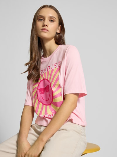 Kobiece modelko nosi Damski t-shirt Relaxed Fit T-Shirt aus reiner Baumwolle Model 'CARTY' od ONLY, efekt: jednolity kolor, nadruk z motywem, okrągły dekolt, krótki rękaw, dżersej, bawełna; zbliżenie na górną część ciała.