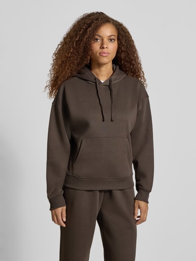 Frauenmodel trägt Regular Fit Hoodie aus Baumwoll-Mix Modell 'BEST' von ONLY in Dunkelbraun, glatte Textur, Ganzkörperansicht von vorne, Damen Hoodie von ONLY.