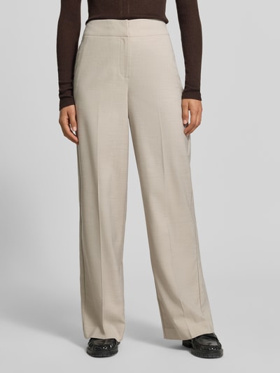 Frauenmodel trägt Wide Fit Hose mit Viskose-Anteil von MYON in Beige, mit Bügelfalten und elastischem Bund, Nahaufnahme Oberkörper.