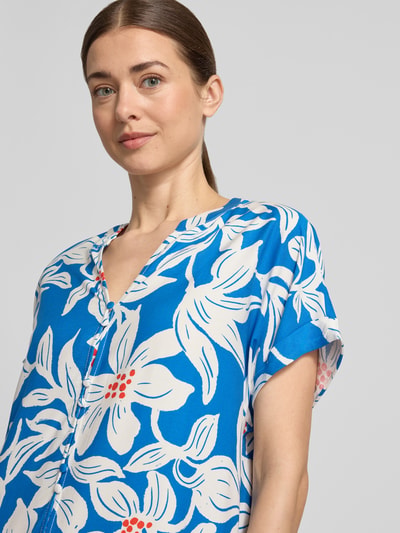Frauenmodel trägt Knielanges Kleid aus Viskose mit Knopfleiste Modell 'Rylie' von GUIDO MARIA KRETSCHMER WOMAN in Blau mit floralem Muster, gerader Schnitt, Serafino-Kragen, Ärmel mit fixiertem Aufschlag, Nahaufnahme Oberkörper.