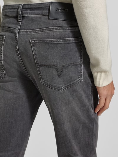 Männermodel trägt Regular Fit Jeans mit Stretch-Anteil Modell 'Mitch' von JOOP! Jeans, Baumwoll-Mix, Label-Patch, Detailaufnahme Rückansicht.