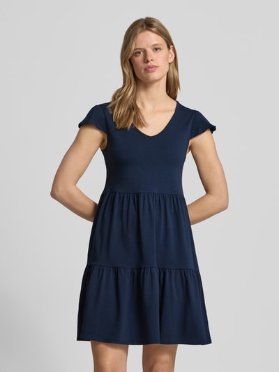Frauenmodel trägt Minikleid im Stufen-Look mit V-Ausschnitt von REVIEW aus Baumwoll-Elasthan-Mix, A-Linie, dunkelblau, Nahaufnahme Oberkörper.