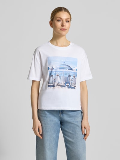 Frauenmodel trägt T-Shirt mit Motiv-Print Modell 'Beach Dogs' von monari aus reiner Baumwolle, weiß, Regular Fit, Nahaufnahme Oberkörper.