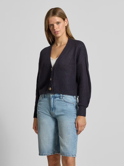 Vrouwenmodel draagt boxy fit gebreid jack met v-hals model 'CAROL' van ONLY in donkerblauw, Dames gebreid jack, volledige vooraanzicht.
