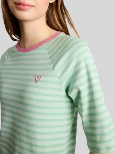 Frauenmodel trägt Shaped Fit T-Shirt aus reiner Baumwolle von Tom Tailor Denim in Optik: Unifarben mit Gestreift, Label-Stitching-Applikation, Herz-Stitching, Rundhals, Feinripp, Kurzarm, Muster, Materialverarbeitung: Feinripp, Ganzkörperansicht von vorne.