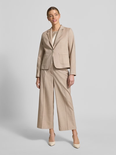 Frauenmodel trägt Regular Fit Blazer mit Reverskragen und Knopfverschluss von More & More in Beige, glatte Textur, aufgesetzte Taschen, Material-Mix mit Viskose-Anteil, Ganzkörperansicht von vorne.