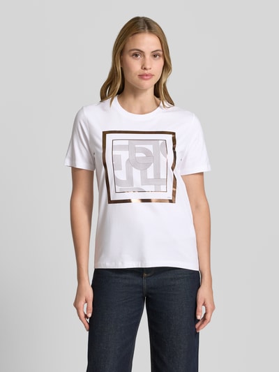 Frauenmodel trägt T-Shirt mit Motiv-Print von comma, weiß mit kantigem Print, Regular Fit, Rundhalsausschnitt, Ganzkörperansicht von vorne.
