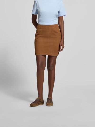 Frauenmodel trägt Minirock aus echtem Ziegenvelours von ROTATE in Braun, Slim-Fit, Strukturmuster, Nahtreißverschluss, Suede-Optik, Ganzkörperansicht von vorne.
