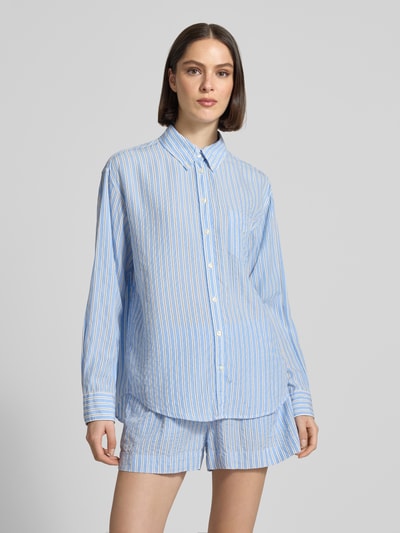 Frauenmodel trägt Relaxed Fit Bluse aus Lyocell mit Button-Down-Kragen von Gant, blau-weiß gestreift, mit Brusttasche, Knopfleiste, Rückenlänge bei Größe 36: 73 cm, Ärmellänge bei Größe 36: 59 cm, Ganzkörperansicht von vorne.
