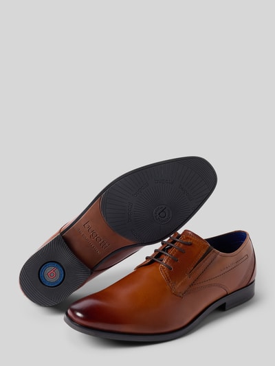 Produktfoto, brązowe Schnürschuhe mit Label-Detail Modell 'Savio' von bugatti z prawdziwej skóry, zaokrąglony nosek, fakturowana podeszwa, kontekst męskie półbuty, obcas 2 cm, cholewka 8 cm.