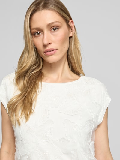 Frauenmodel trägt Regular Fit T-Shirt aus Viskose-Mix von s.Oliver BLACK LABEL in Weiß mit Pailletten und Mesh, unifarben, Nahaufnahme Oberkörper.
