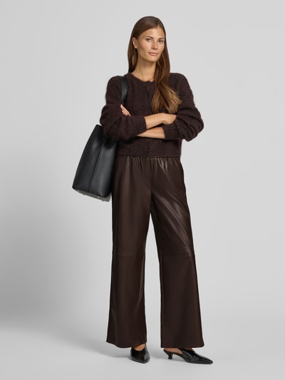 Vrouwenmodel draagt Wide Fit broek in leerlook van comma, donkerbruin, elastische band, steekzakken, bandwijdte maat 36/32: 40 cm, binnenbeenlengte: 75 cm, full body vooraanzicht.