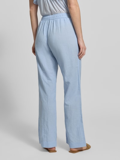 Frauenmodel trägt Stoffhose mit Leinen-Anteil und Eingrifftaschen von Neo Noir, hellblau, ausgestellter Schnitt, Ganzkörperansicht Rückansicht. Baumwoll-Mix, elastischer Bund, französische Eingrifftaschen, Modell 'Sonar', Bundweite 36 cm, Innenbeinlänge 79 cm.