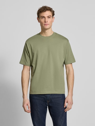 Männermodel trägt Regular Fit T-Shirt aus reiner Baumwolle von MCNEAL in Olivgrün, Rundhalsausschnitt, kurzärmelig, Ganzkörperansicht von vorne.