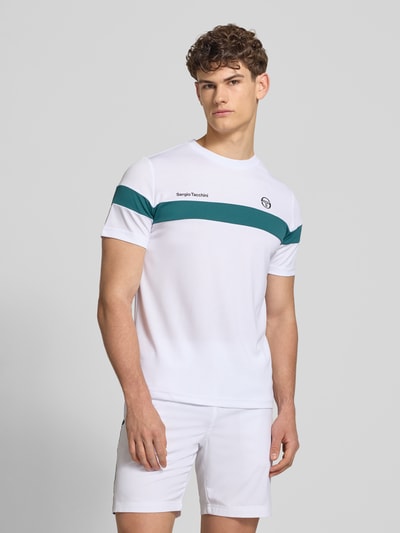 Männermodel trägt weißes Regular Fit T-Shirt mit grünem Logo-Print Modell 'Leone' von SERGIO TACCHINI, Rundhals, Ganzkörperansicht von vorne.