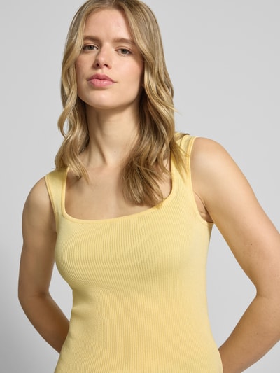 Frauenmodel trägt Top aus Viskose-Mix mit Karree-Ausschnitt Modell 'POSIE' von JJXX, Slim-Fit, gelb, Struktur mit feiner Rippung, Nahaufnahme Oberkörper. Rückenlänge bei Größe S: 52 cm.