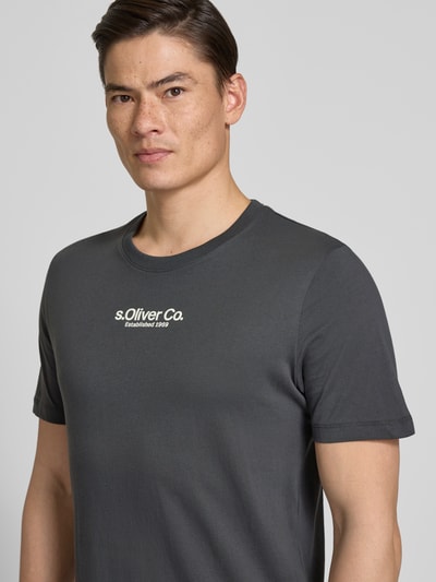 Männermodel trägt Regular Fit T-Shirt aus reiner Baumwolle von s.Oliver RED LABEL, unifarben, Kurzarm, Label-Schriftzug, Jersey, Nahaufnahme Oberkörper.