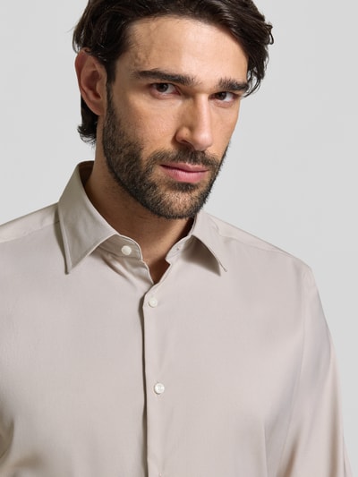 Männermodel trägt Regular Fit Businesshemd aus Stretch-Twill Modell 'P-JOE-KENT-C1-222' von BOSS in Beige, Nahaufnahme Oberkörper.