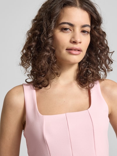 Frauenmodel trägt Slim Fit Top in Falten-Optik von Gina Tricot in Rosa, ärmellos, elastischer Mix, Nahaufnahme Oberkörper.