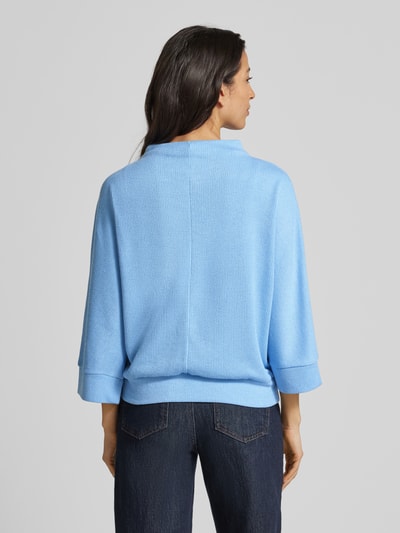 Frauenmodel trägt Longsleeve mit 3/4-Ärmel Modell 'Sagida' von Opus, Material-Mix mit Viskose-Anteil, Lockere Schnitt, Stehkragen, gerippte Abschlüsse, Rückenlänge bei Größe 36: 60 cm, einfarbig hellblau mit strukturierter Textur, Ganzkörperansicht Rückansicht.