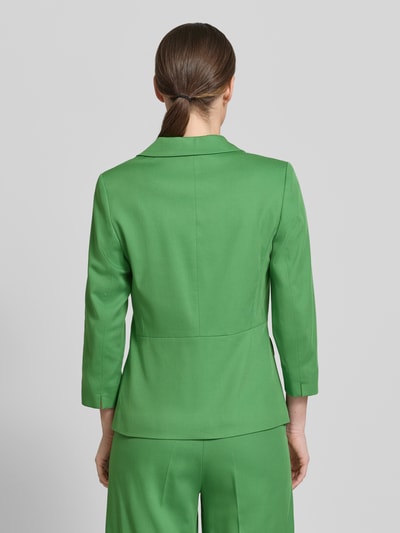 Frauenmodel trägt Slim Fit Blazer mit 3/4-Arm von More & More in Grün, Baumwoll-Viskose-Mix, Reverskragen, Pattentaschen, Ganzkörperansicht Rückansicht.