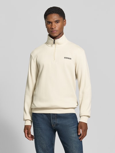 Männermodel trägt Relaxed Fit Sweatshirt aus elastischem Baumwoll-Mix von Napapijri in Beige mit Label-Detail, Troyer-Kragen, elastischen Abschlüssen, Ganzkörperansicht von vorne.