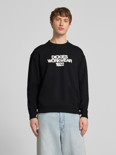 Männermodel trägt Sweatshirt mit Label-Print Modell 'TORREY' von DICKIES in Schwarz, Baumwoll-Mix, Lockerer-Schnitt, Rundhalsausschnitt, Gerippte-Abschlüsse, Ganzkörperansicht von vorne.