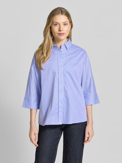 Frauenmodel trägt Regular Fit Hemdbluse mit durchgängiger Knopfleiste von Christian Berg Woman, blau-weiß gestreift, reine Baumwolle, Halbarm, Hemdblusenkragen, lockerer Schnitt, glatte Textur, Ganzkörperansicht von vorne.
