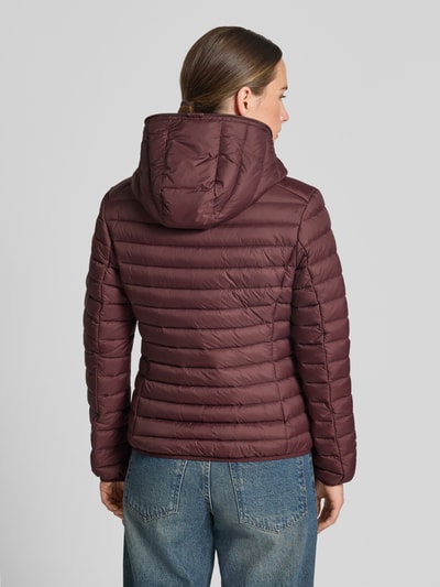 Männermodel trägt kurtka pikowana Steppjacke mit Zweiwege-Reißverschluss Modell 'DAISY' von Save The Duck, krój slim fit, Kaptur, brązowa, tekstura pikowana, Kieszenie zapinane na zamek błyskawiczny, Długość tyłu w rozmiarze S: 57 cm, szerokość ramion w rozmiarze S: 44 cm, szerokość klatki piersiowej w rozmiarze S: 48 cm, Długość rękawów w rozmiarze S: 60 cm, Ganzkörperansicht Rückansicht