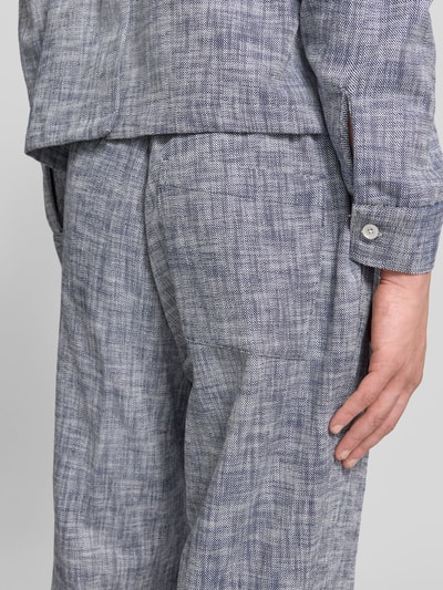 Männermodel trägt Wide Fit Stoffhose mit Bügelfalten von Officine Générale aus Reine Baumwolle, melierte Textur, Nahaufnahme Oberschenkel.