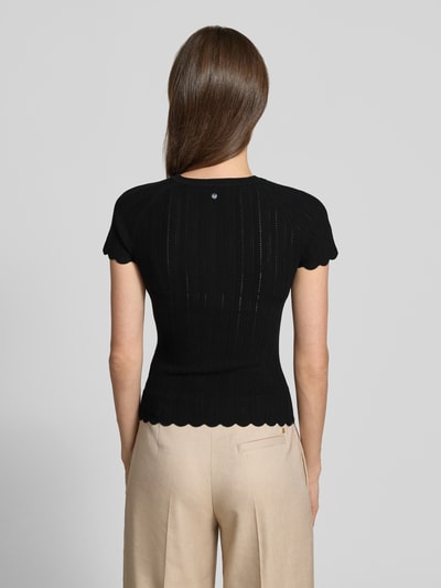 Frauenmodel trägt Slim Fit Strickpullover aus Viskose-Mix Modell 'FICE' von BOSS Orange, Schwarz, Struktur-Muster, Kurzarm, Strickoptik, Label-Applikation, Ganzkörperansicht Rückansicht.