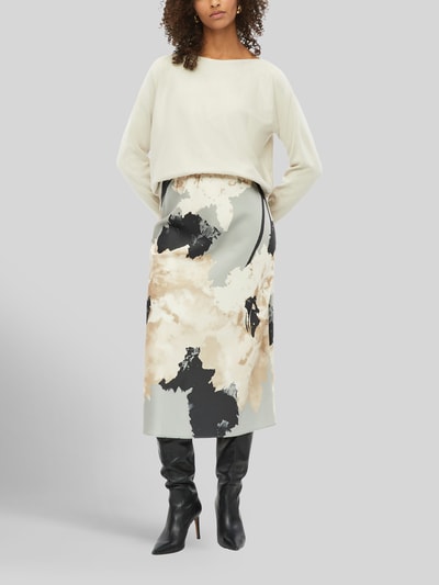 Frauenmodel trägt Relaxed Fit Pullover aus Viskose-Mix von s.Oliver BLACK LABEL in Beige, kombiniert mit gemusterter Rock, Ganzkörperansicht von vorne.