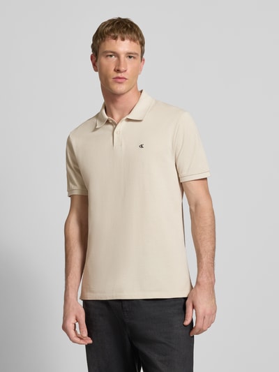 Männermodel trägt Straight Fit Poloshirt mit Label-Stitching von Calvin Klein Jeans aus reiner Baumwolle, Polokragen, Nahaufnahme Oberkörper.